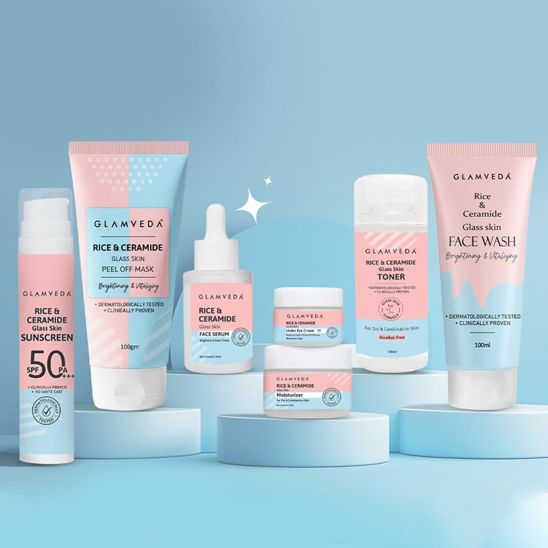 Glamveda Rice & Ceramide Glass Skin range — sunscreen, peel-off mask, serum, under-eye cream, moisturizer, toner and face wash arranged on pale-blue pedestals