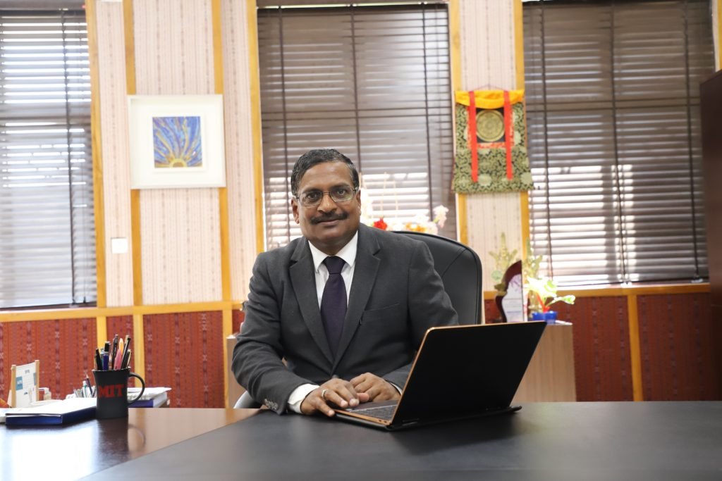 Professor Mahadeo Jaiswal, Founding Director of IIM Sambalpur, seated at his office desk with a laptop